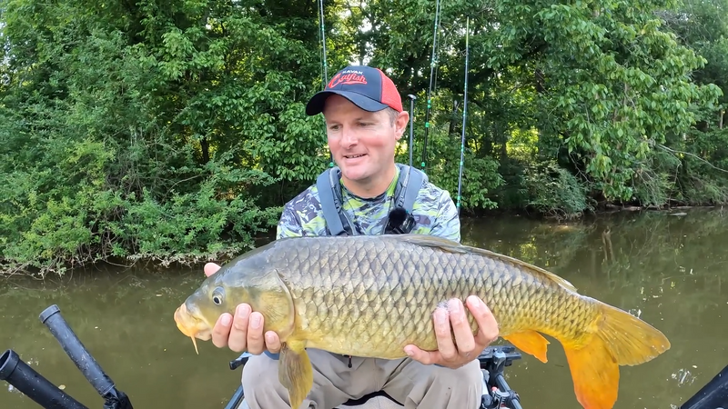 man holding carp after catching it