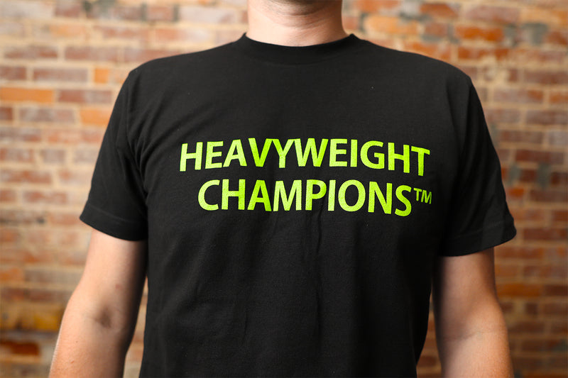 black t-shirt with green letters that say heavyweight champions